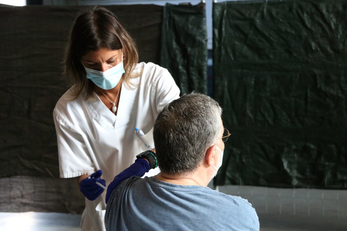 Una infermera vacunant un home en un punt de vacunació a Catalunya