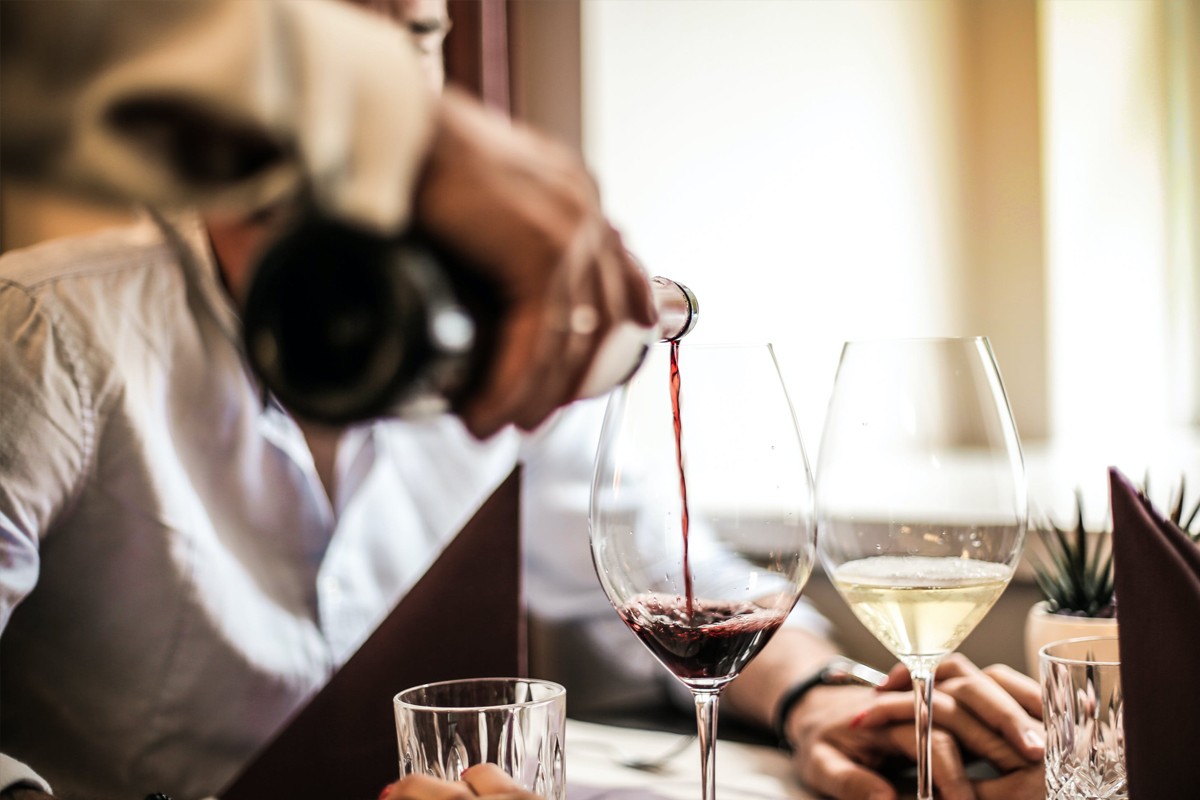 Imatge d'arxiu d'un restaurant amb un cambrer servint vi