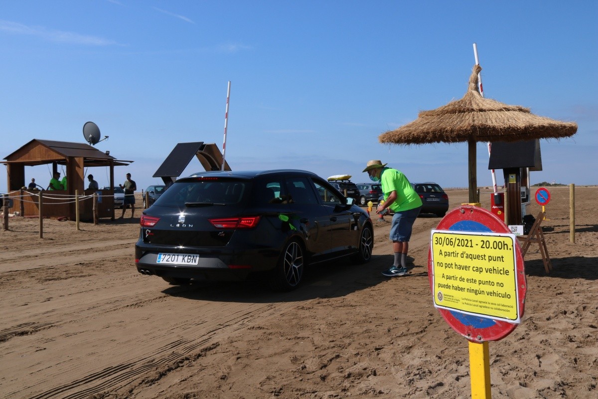 Un agent cívic i d’un vehicle accedint a la platja del Trabucador en el primer dissabte de la nova regulació.
