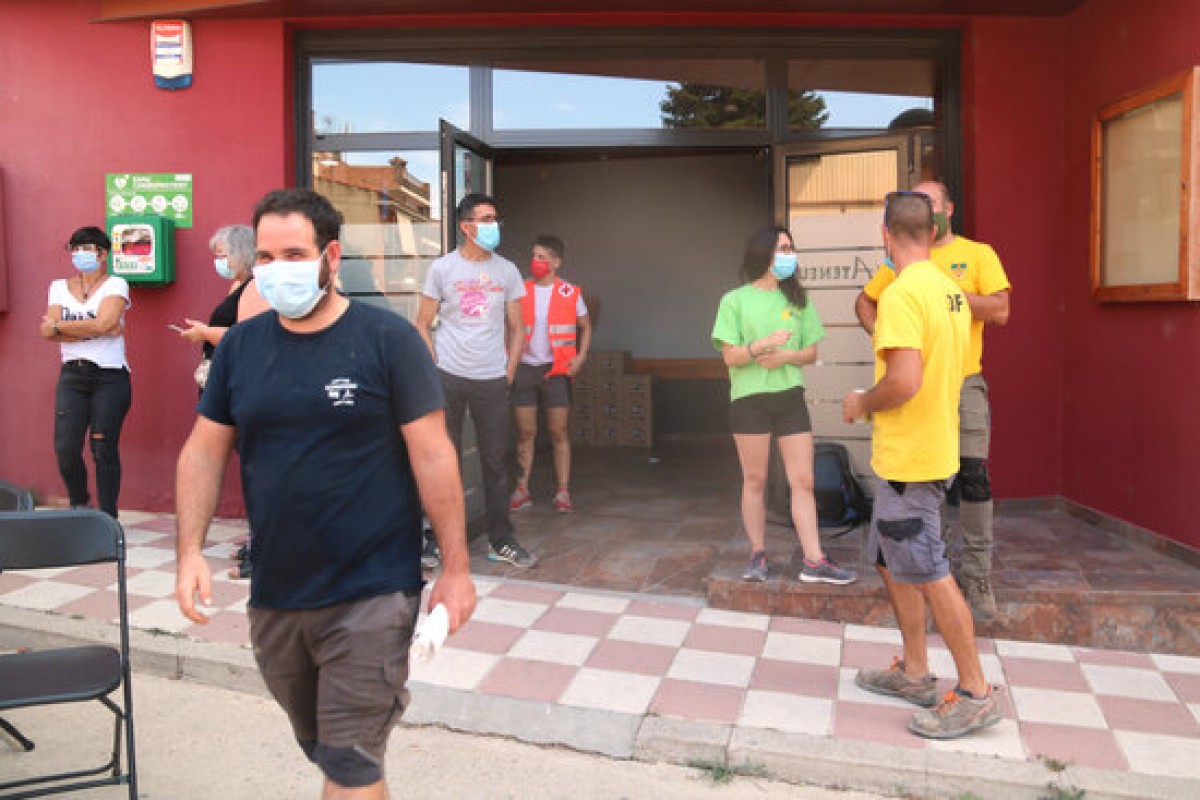 Voluntaris a l'entrada de l'Ateneu de Sant Martí de Tous que participen en les tasques per apagar el foc que crema a les comarques de la Conca de Barberà i l'Anoia