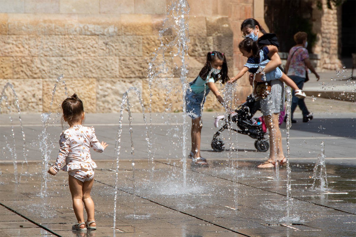 Nens refrescant-se a la font de la plaça Sant Roc 