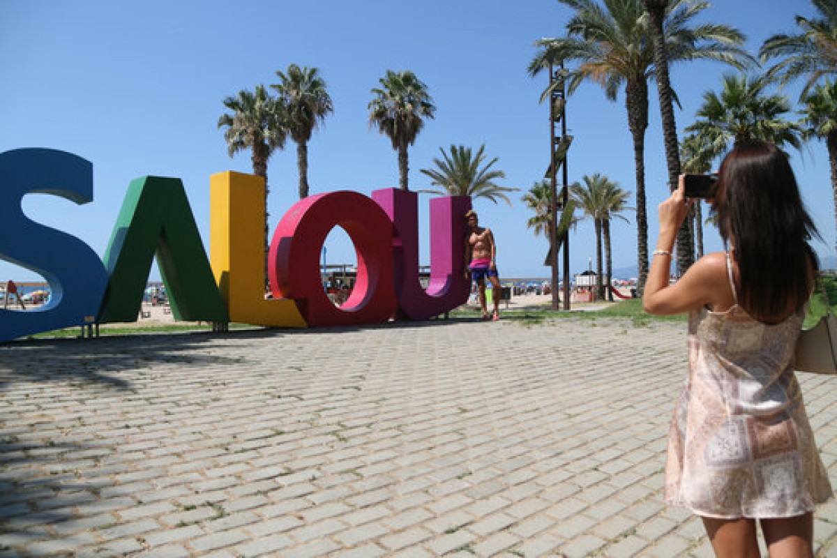 Una parella de turistes que es fotografien a les lletres de Salou