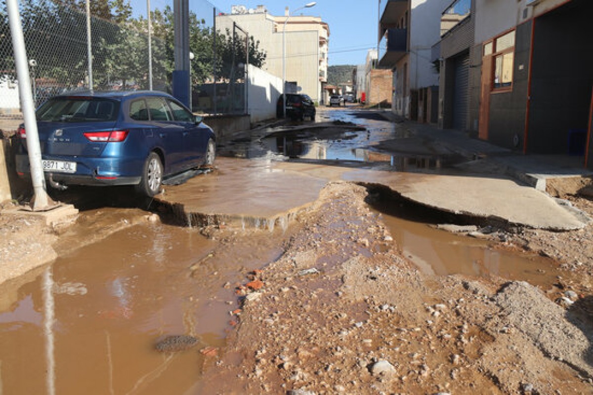Pla obert del carrer Joan Maragall d'Alcanar, amb un cotxe que l'aigua va moure de lloc.
