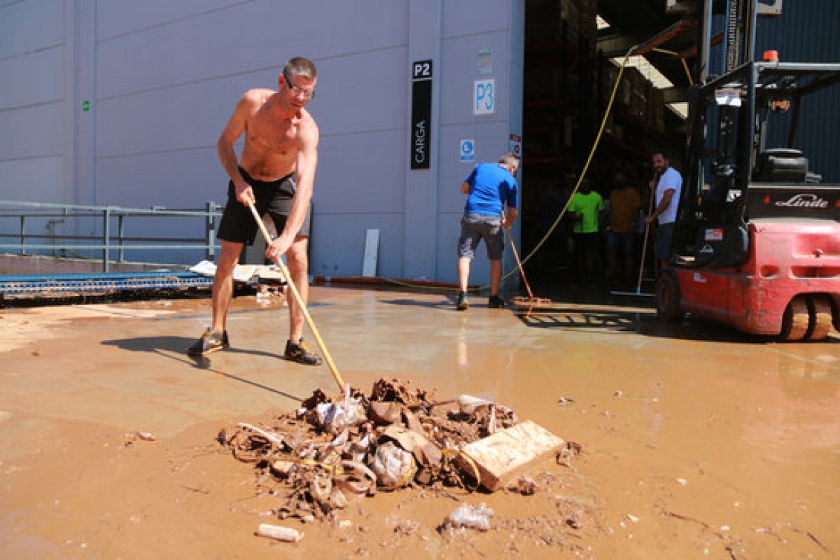 Pla obert d'un treballador d'una empresa de mobles de bany del polígon industrial Valldepins d'Ulldecona, durant les tasques de neteja després de l'aiguat d'este dimecres. 
