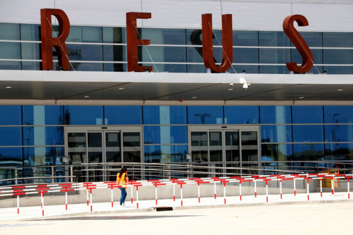 Una operària que passa per davant la nova terminal de l'Aeroport de Reus