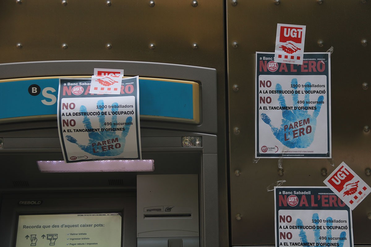 Un caixer de Banc Sabadell, ple de cartells contra l'ERO
