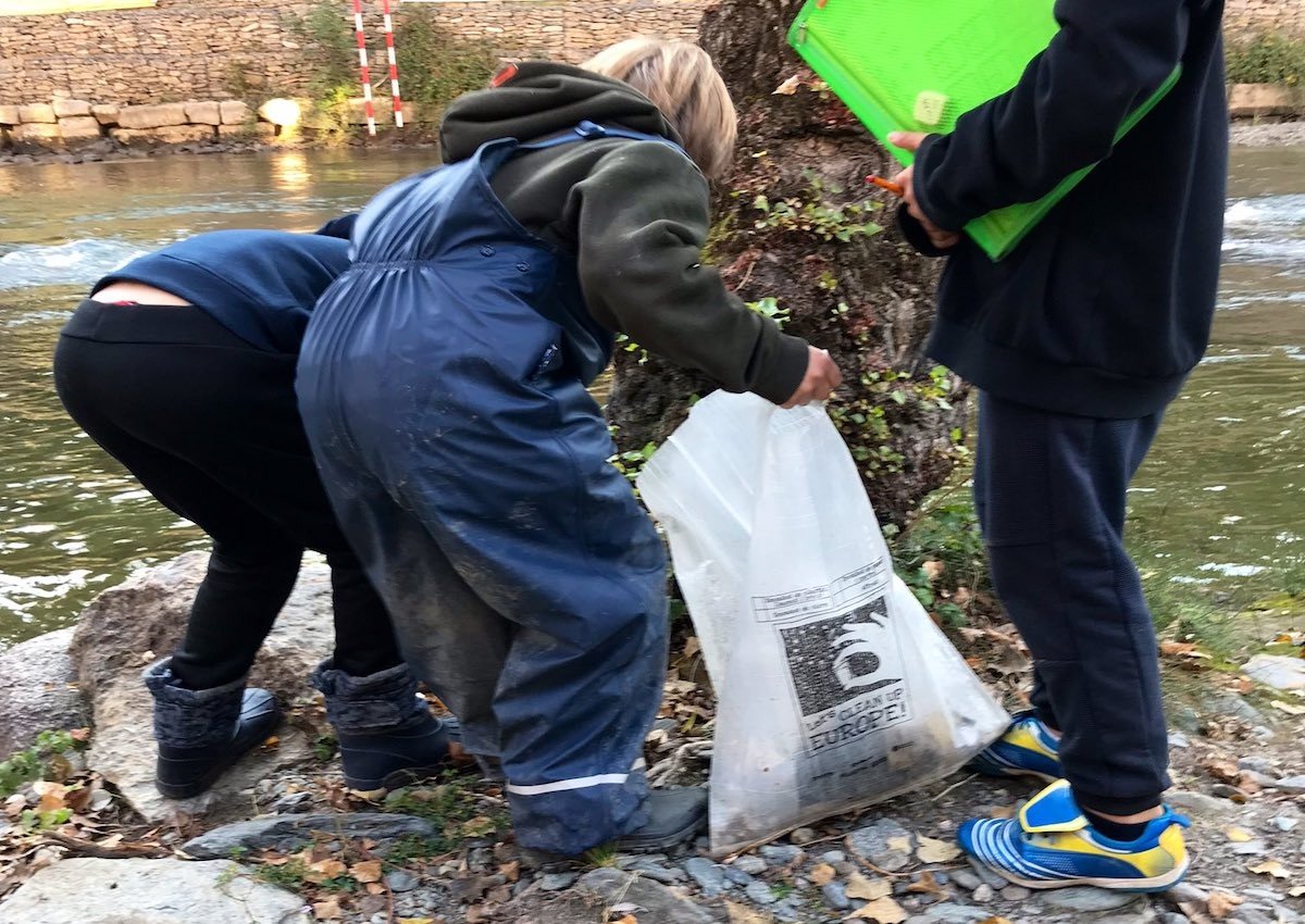 Un nens recollint brossa al riu Noguera Pallaresa al seu pas per Sort