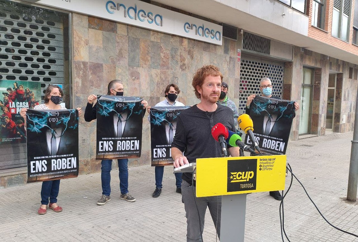 El portaveu de la CUP a Tortosa, Sergi Arnau, acompanyat de militants davant de la seu d'Endesa a Tortosa, on van presentar la moció