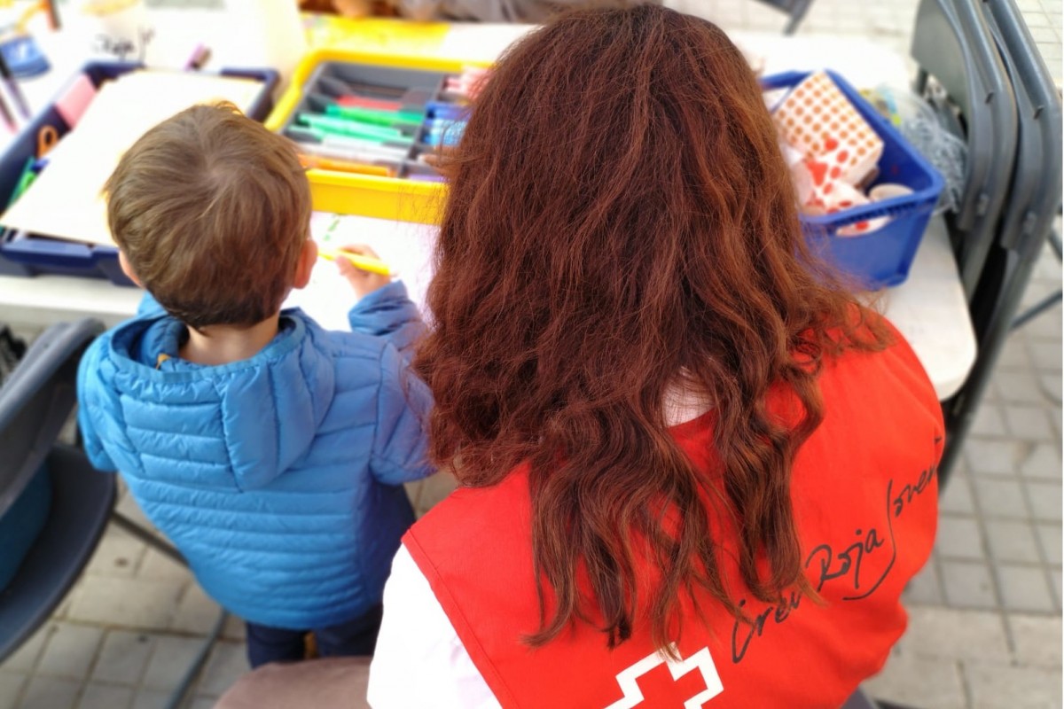 Una voluntària de Creu Roja, amb un infant