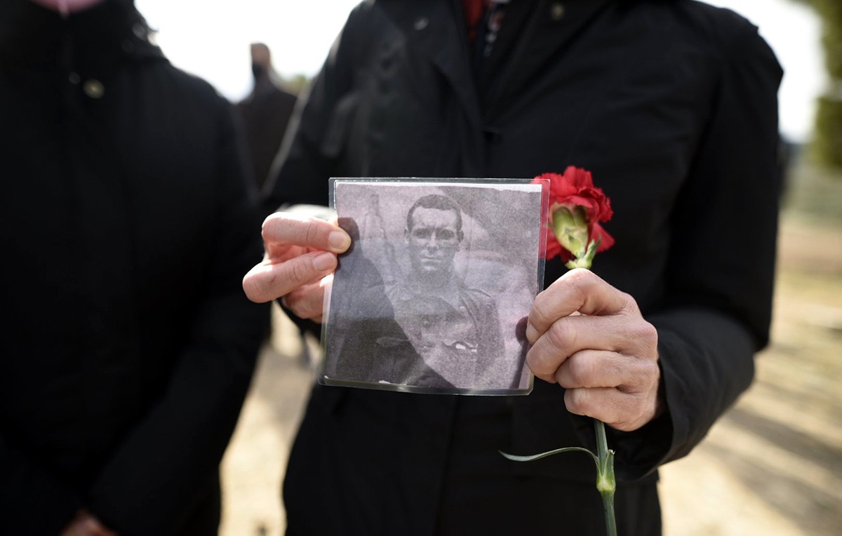 Un familiar ensenya una fotografia d'una de les víctimes de la Batalla de l'Ebre homenatjades al Memorial de les Camposines