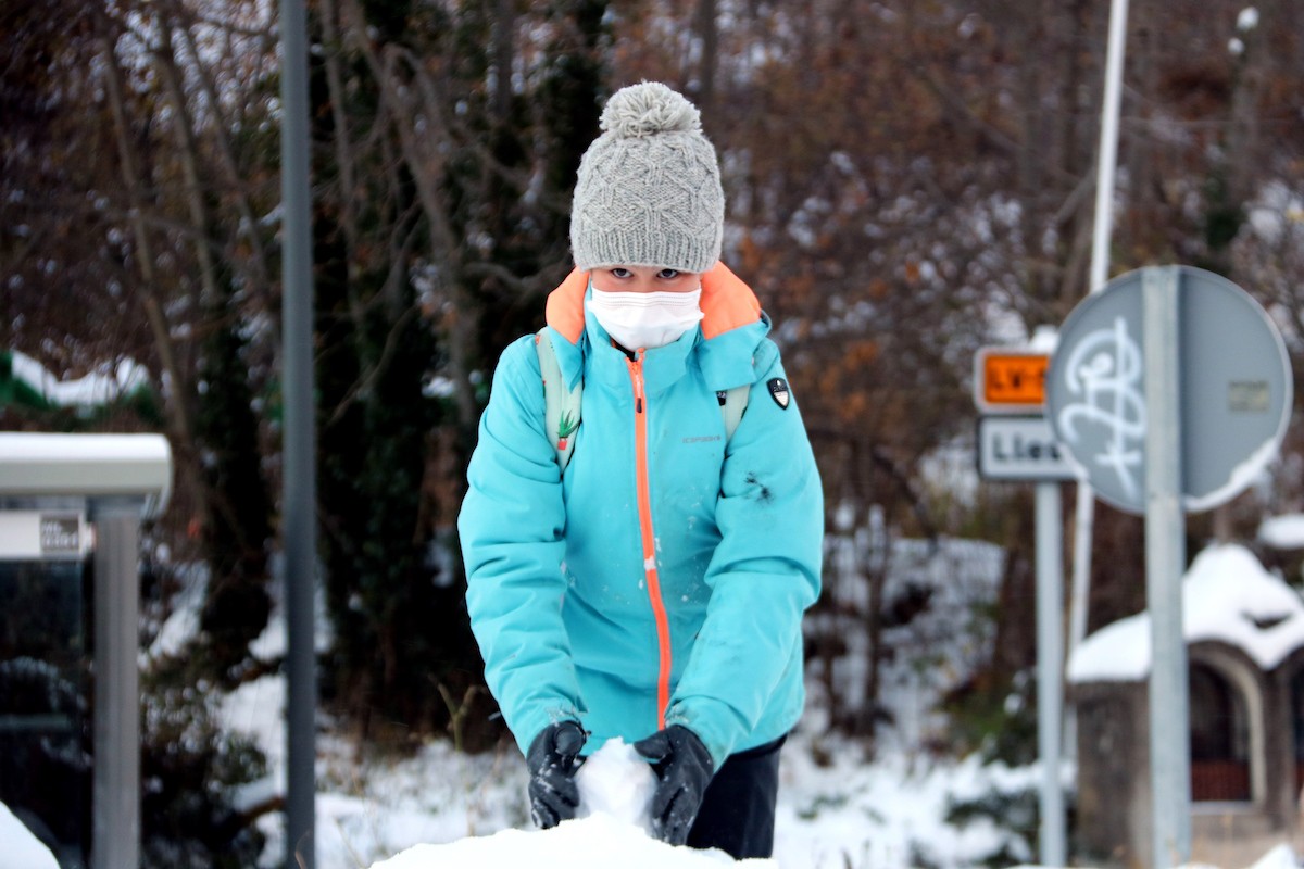 Un nen jugant al carrer un dia d'hivern al Pirineu