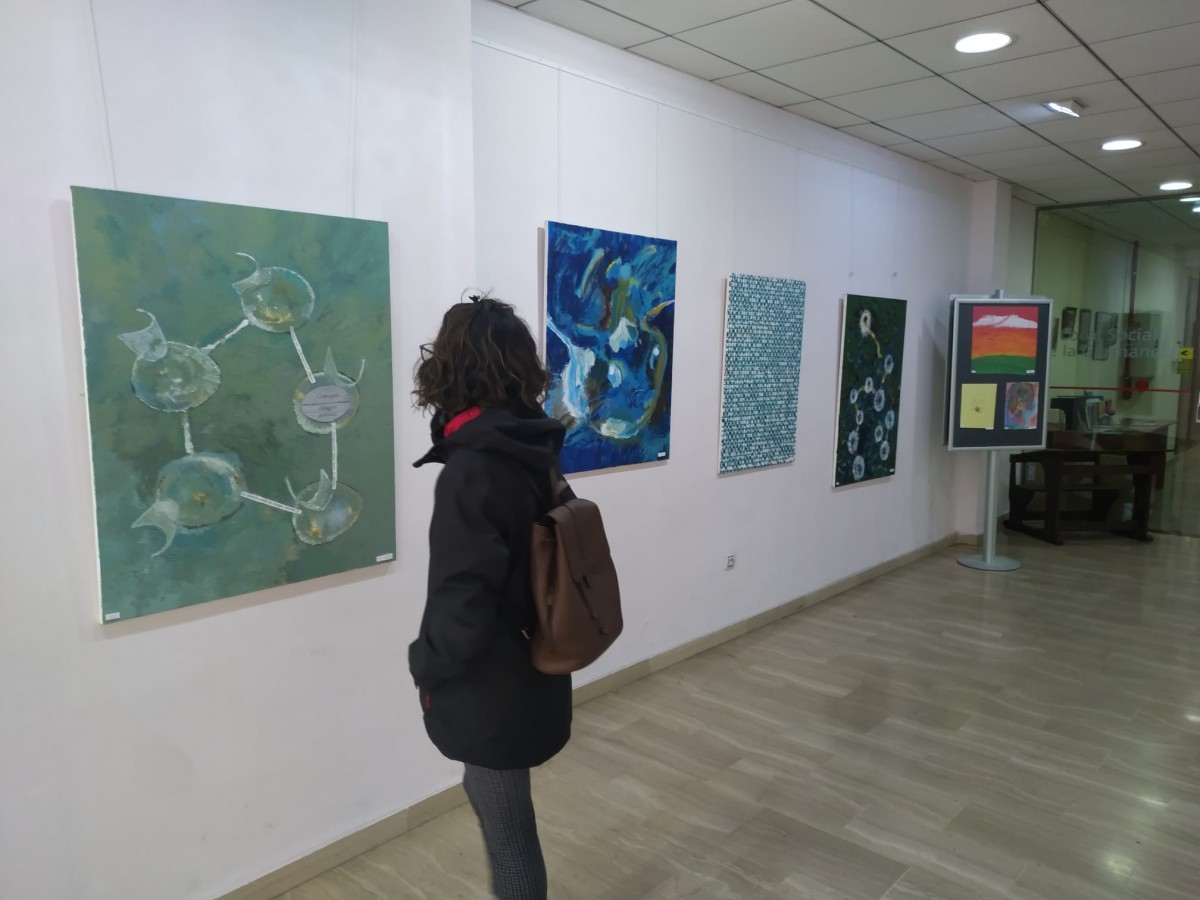 Una noia es mira algunes de les obres de l'exposició