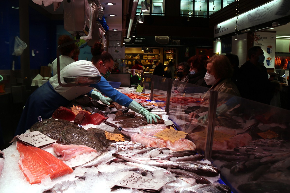 Venedores i clientes comprant per Nadal en una parada de peix del Mercat Central de Tarragona.