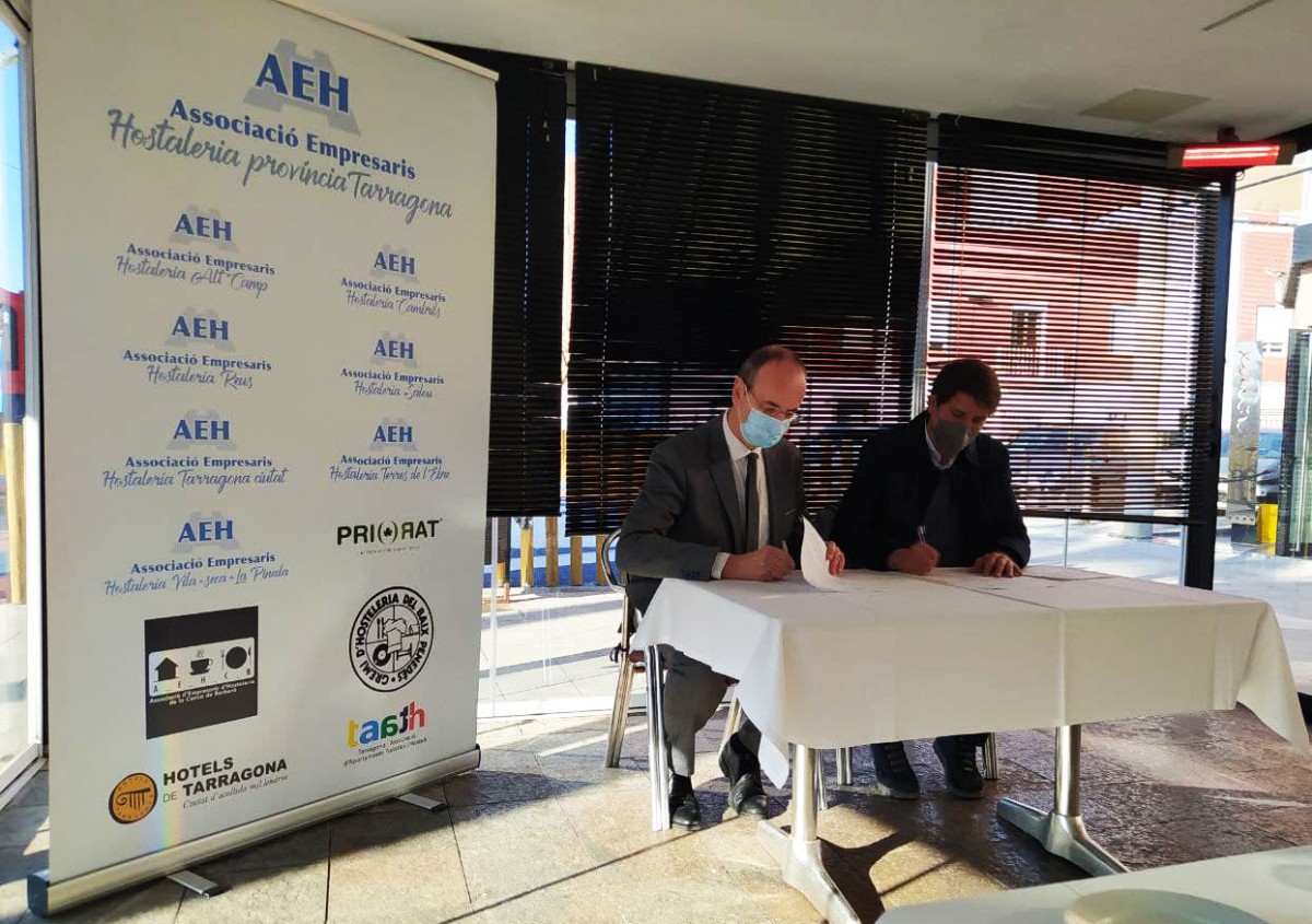 Els representants de Repsol i l'AEHT, Javier Sancho i Francesc Pintado, signant el conveni.