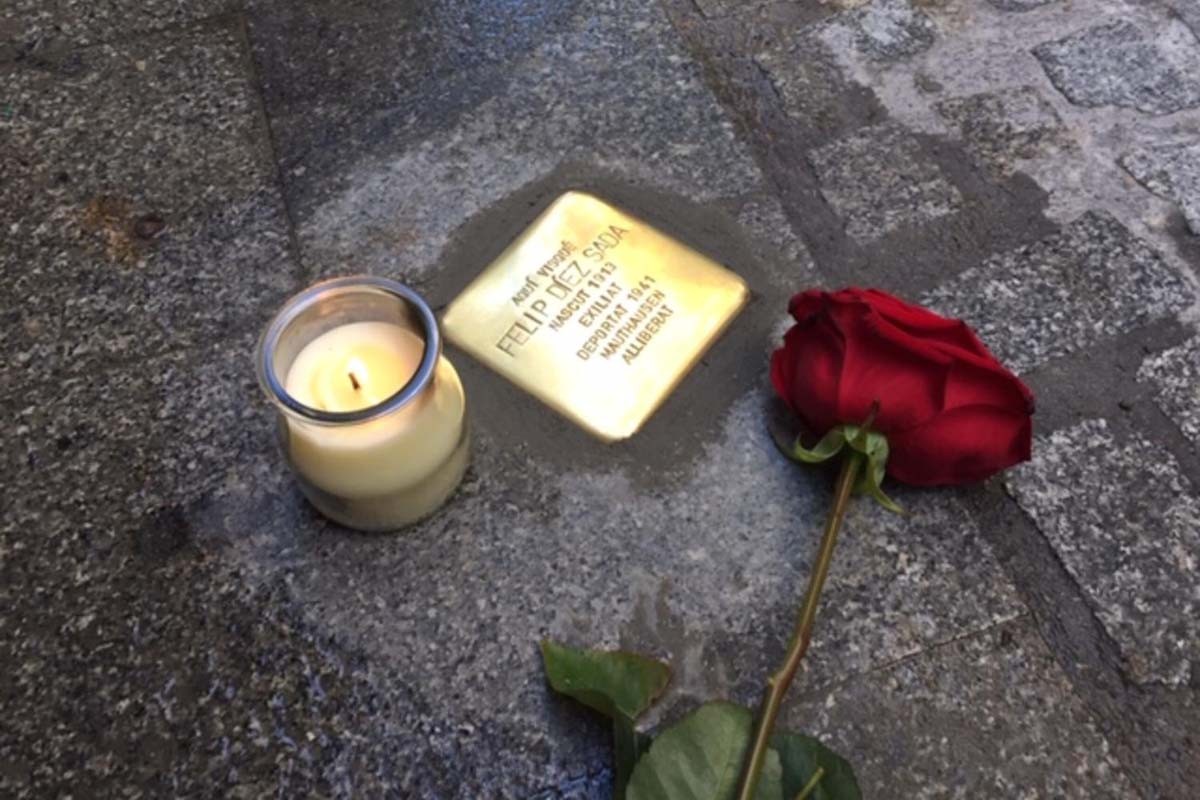 Una rosa i una espelma a la vora d'una rajola «stolpersteine»