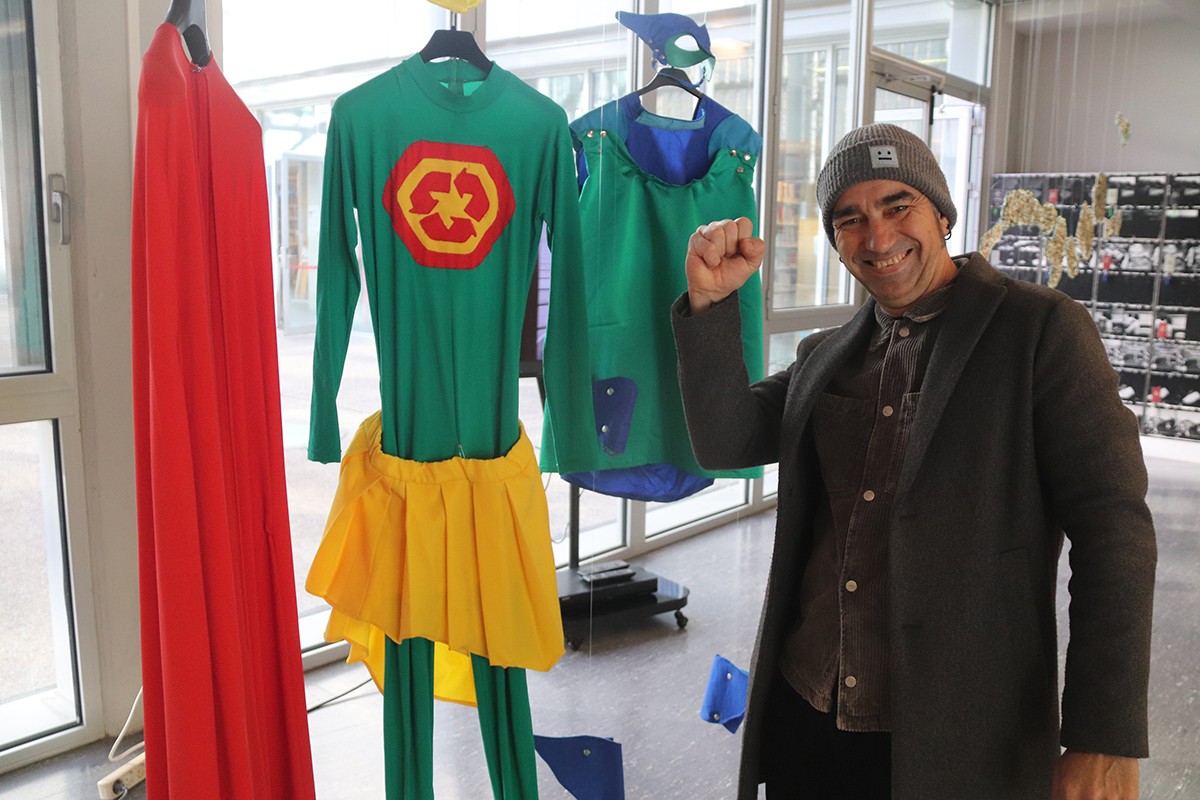 L'artista Jordi Llort-Figuerola amb els vestits del seu alter ego, el superheroi Plastic Hunter, a l'exposició Distopies del plàstic.