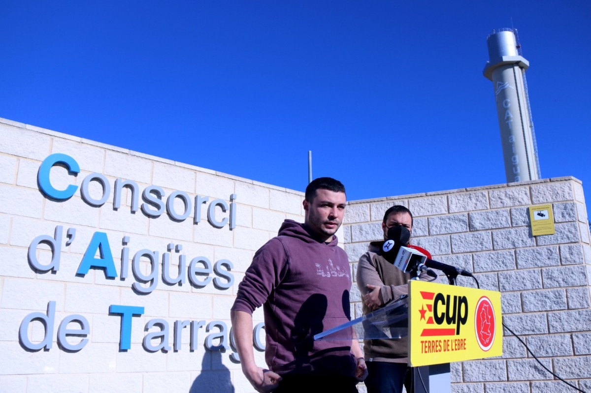 Els regidors de la CUP de Reus, Edgar Fernàndez, i el d'Alcanar-Les Cases, Andreu Carapuig, atenen els mitjans davant la planta del CAT a l'Ampolla .