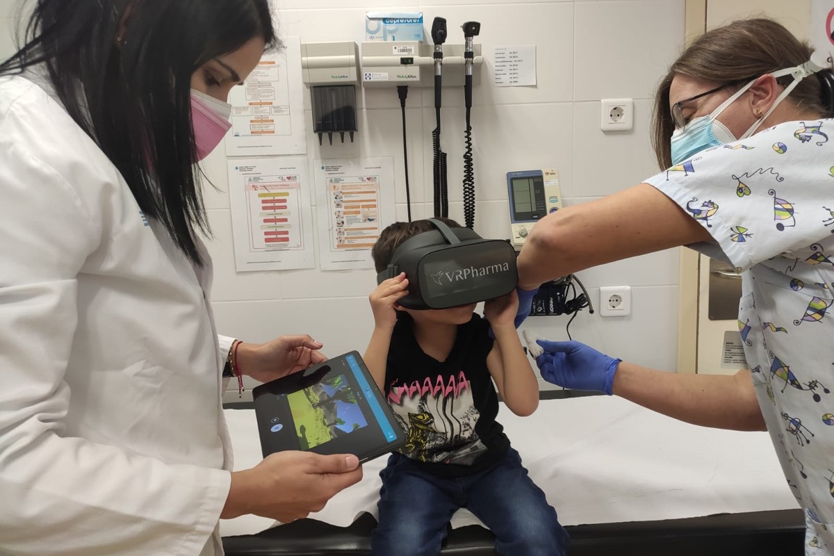 Un infant amb les ulleres de realitat virtual mentre el vacunen