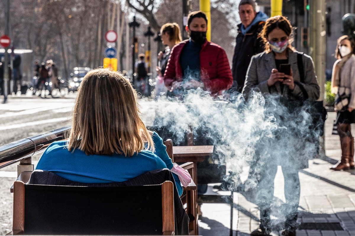 Una dona fumant en una terrassa d'un bar de Barcelona.