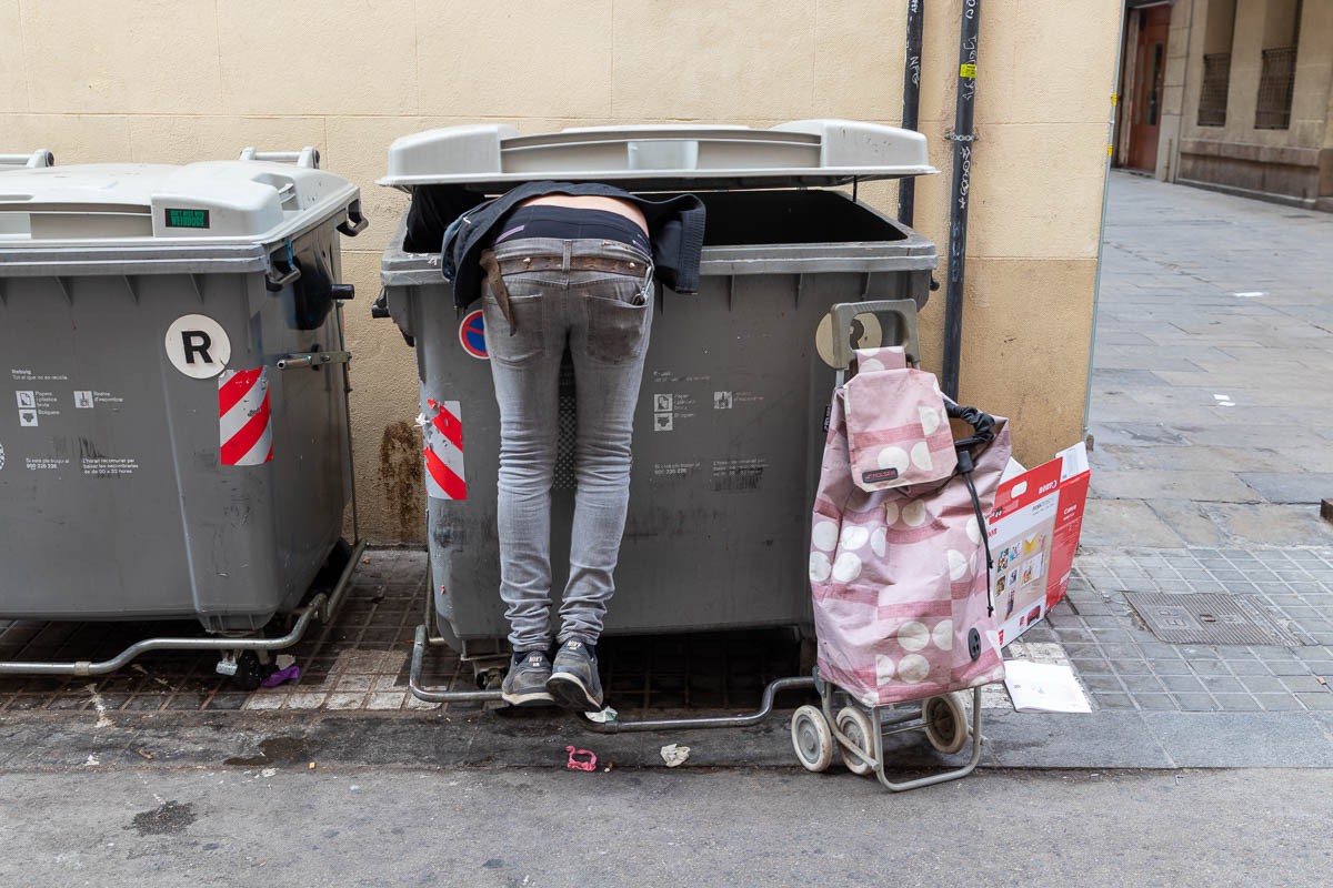 Un home rebusca en un contenidor de Barcelona