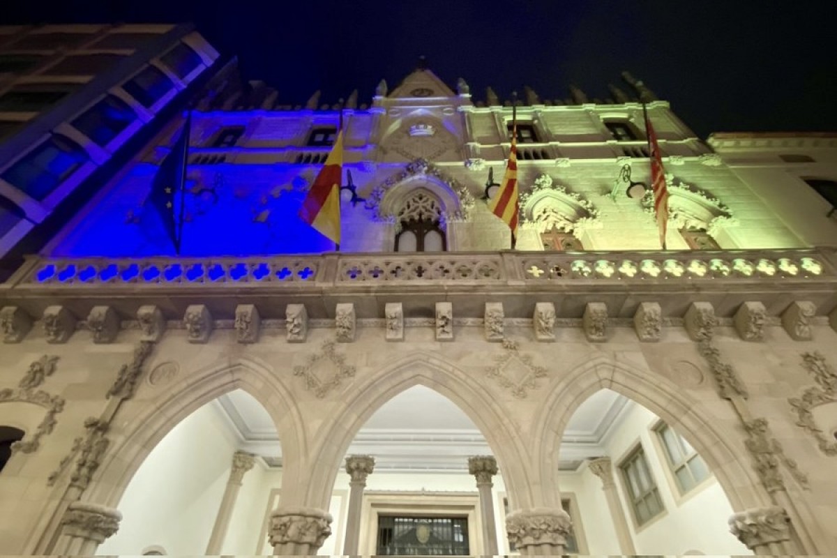 La façana de l'Ajuntament de Terrassa il·luminada amb els colors característics de la bandera d'Ucraïna