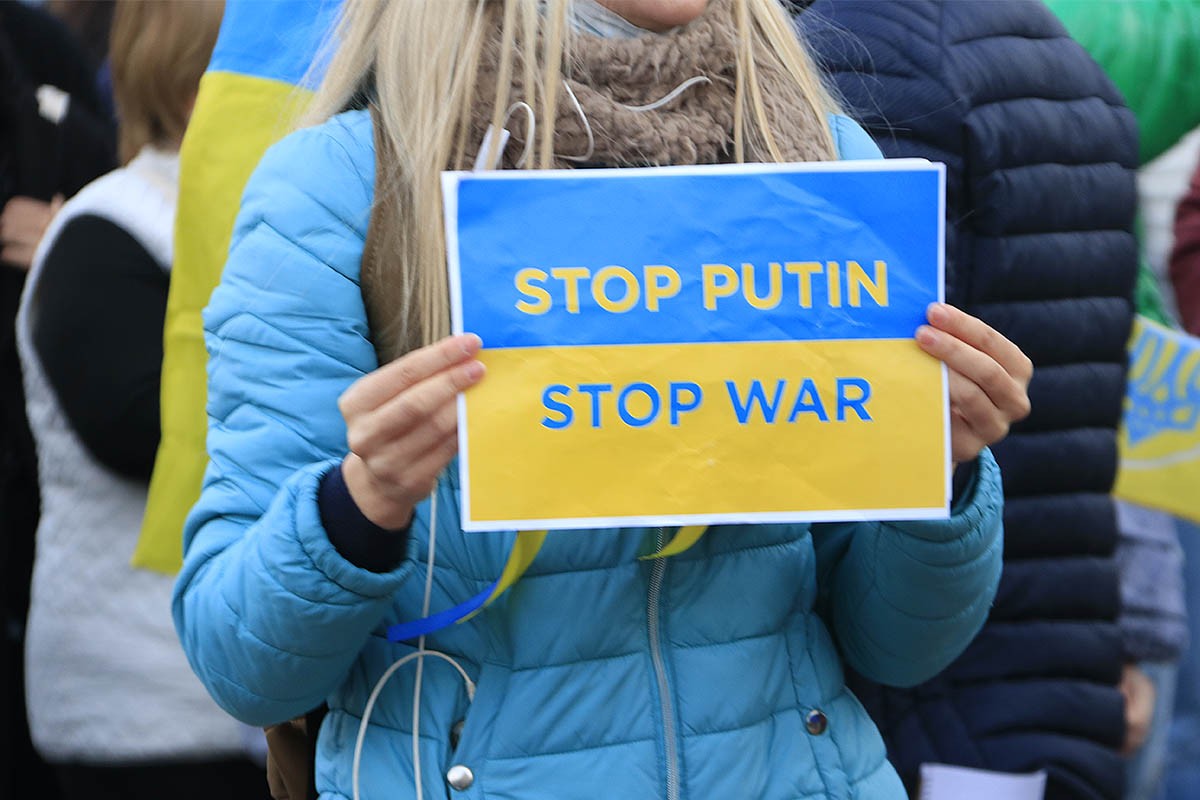 Una dona sosté un cartell que demana que s'aturin la guerra i Putin durant una concentració 