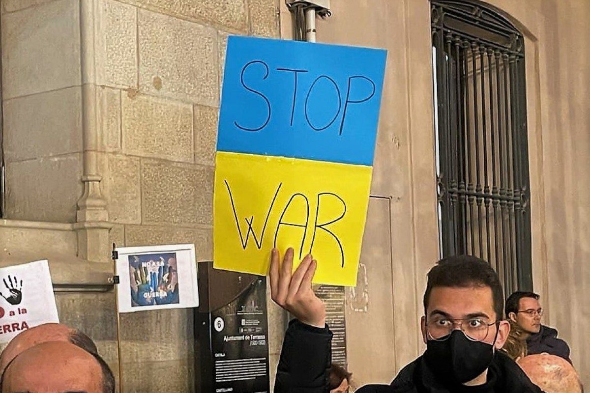 Un home mostra un cartell contra la guerra a Ucraïna