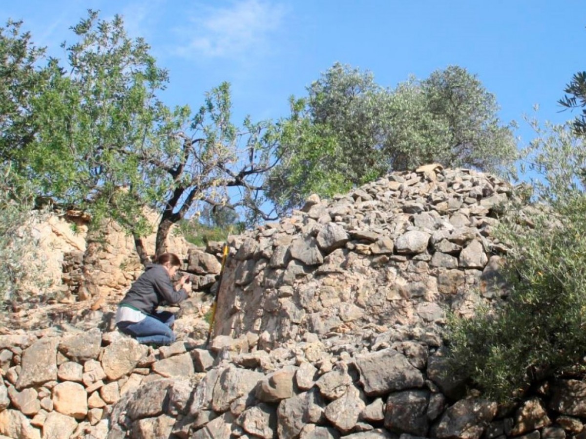 La investigadora Cèlia Mallafré fotografia una construcció de pedra seca