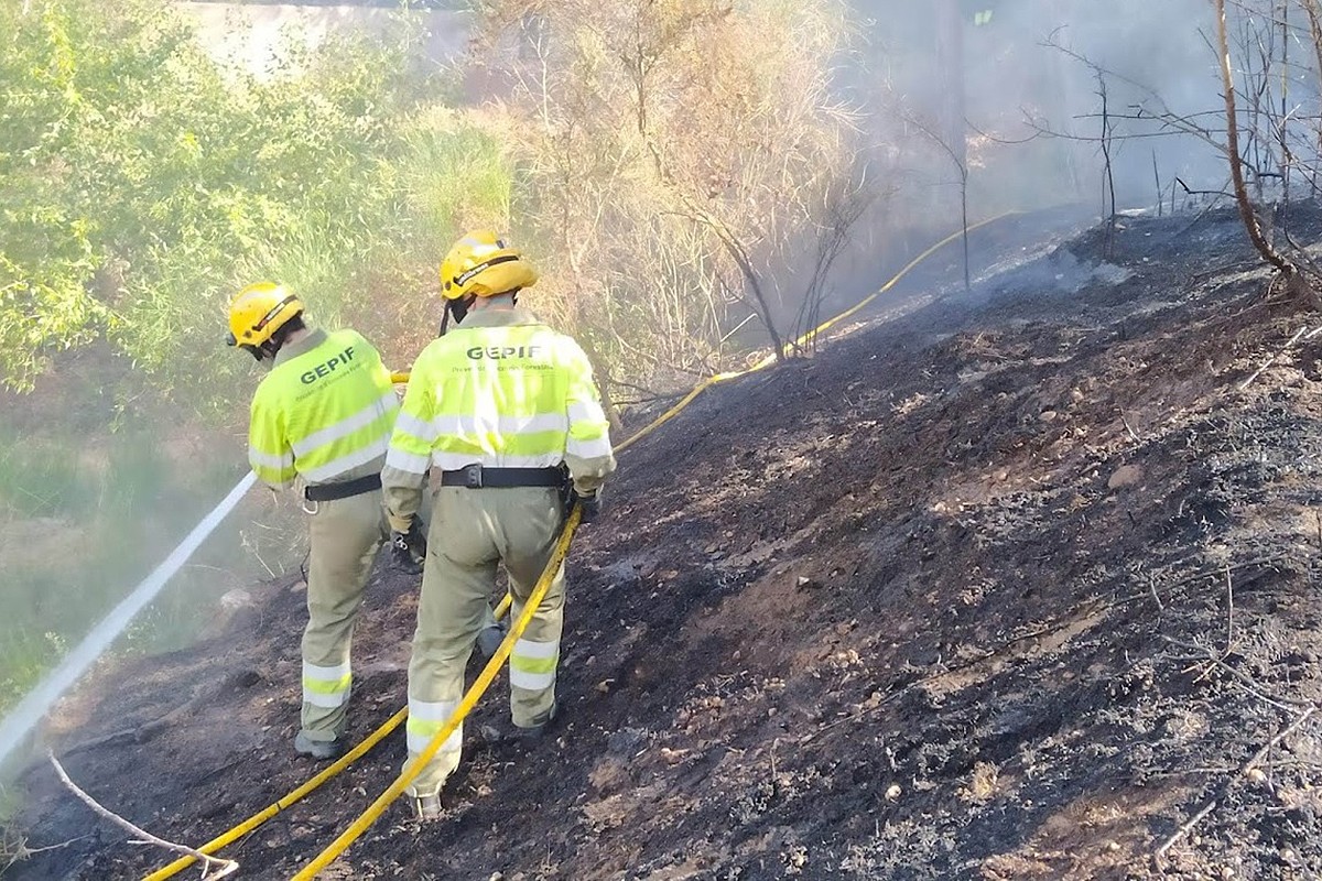 Membres del Grup Especial de Prevenció d'Incendis (GEPIF) remullant una zona cremada.