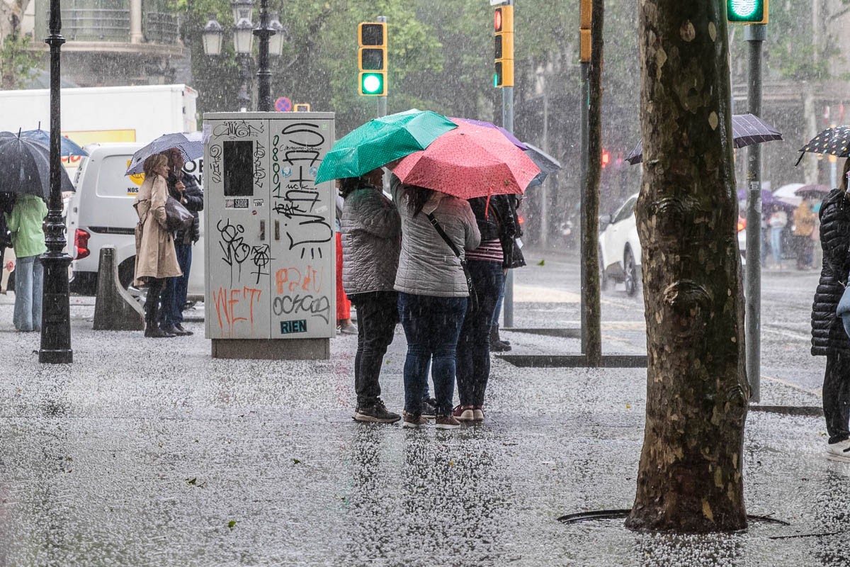 Tres persones sota la pluja