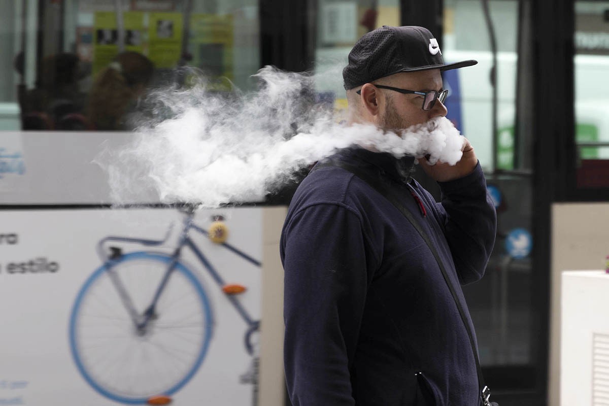 Un home expira el vapor d'una cigarreta electrònica.