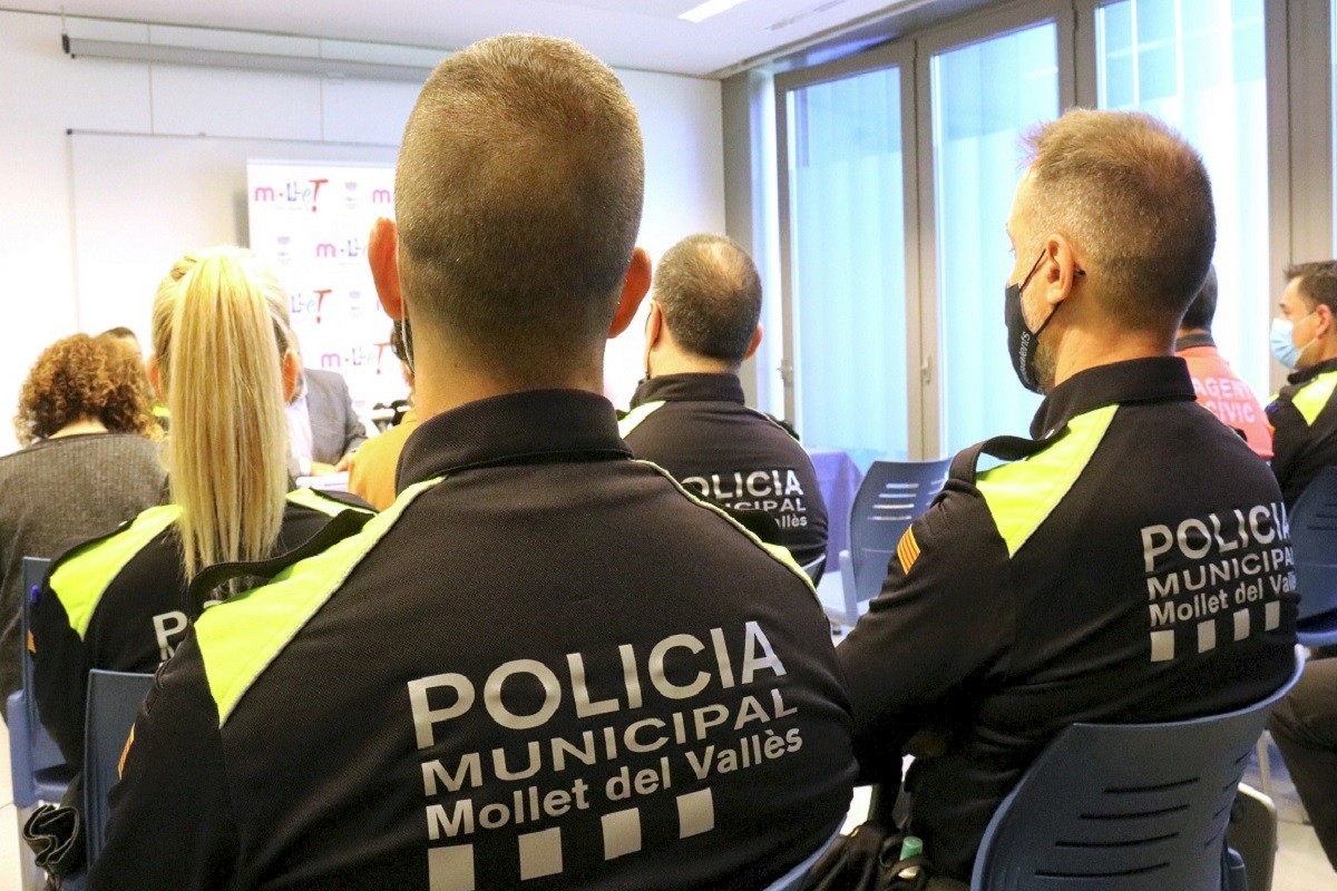 Dos agents de la Policia Municipal de Mollet del Vallès, d'esquena.