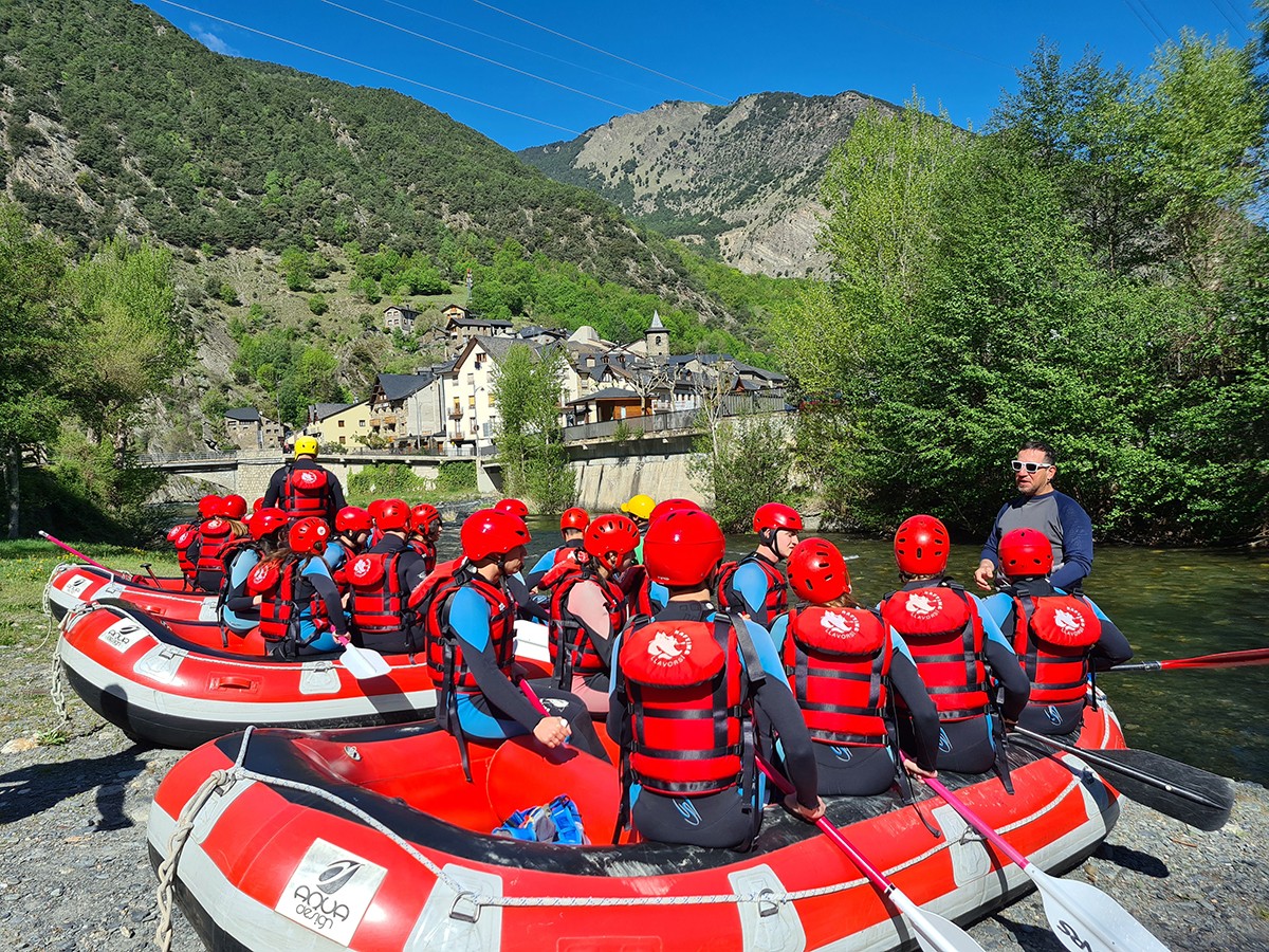 Barques de ràfting plenes de joves preparats per iniciar un descens pel riu Noguera Pallaresa a Llavorsí.