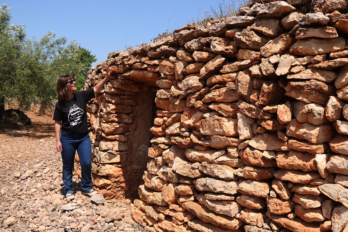 Maria Santiago, membre de la Plataforma Sostenible Camp, mostrant una barraca de pedra seca, afectada pel PDUAE, al terme municipal de Vila-rodona, a l'Alt Camp.