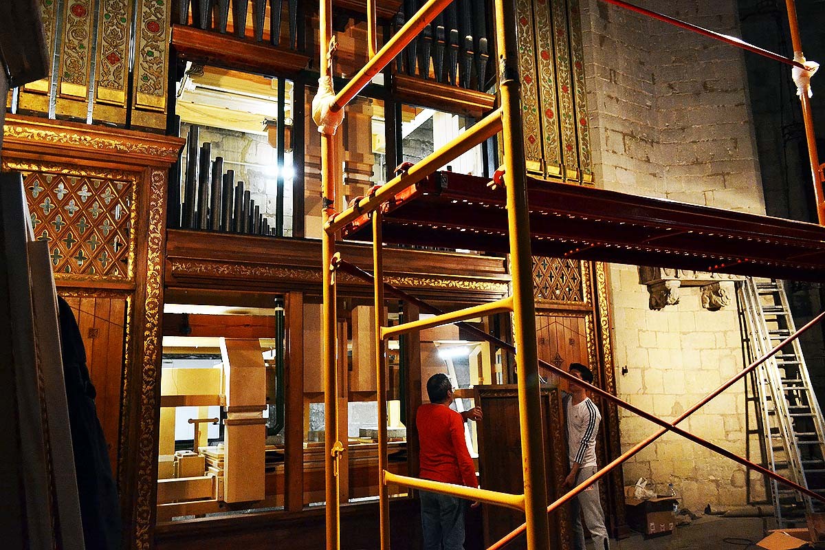 Carlos M. Álvarez i un operari sostenen un plafó de fusta de la coberta de l'orgue
