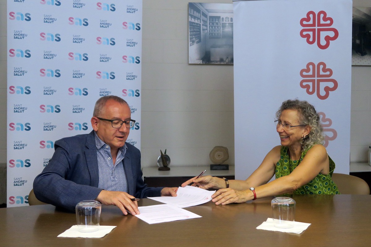 Manel Valls de Sant Andreu Salut i Josefina Farrés de Càritas, signant l'acord de col·laboració