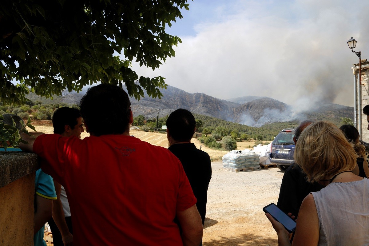 Veïns de Baldomar observant l'incendi forestal a tocar del seu poble