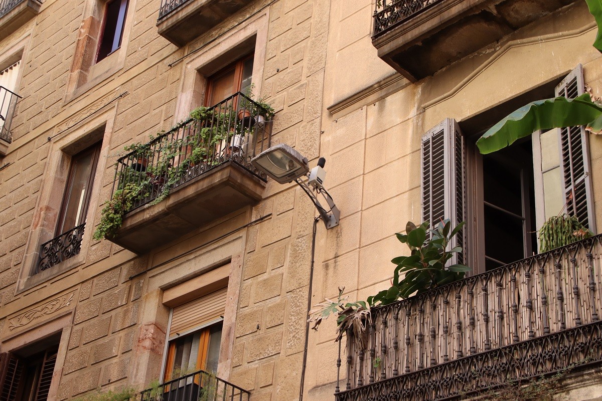 Façana d'un edifici al carrer Joaquín Costa, amb un sonòmetre instal·lat al costat del fanal