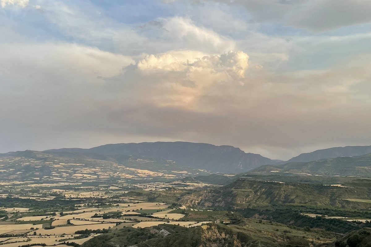 La Conca de Tremp amb el Montsec al fons i el fum de l’incendi de Baldomar