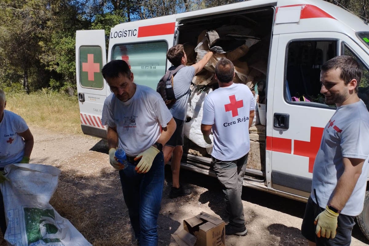 Voluntaris carregant les deixalles en un vehicle de la Creu Roja