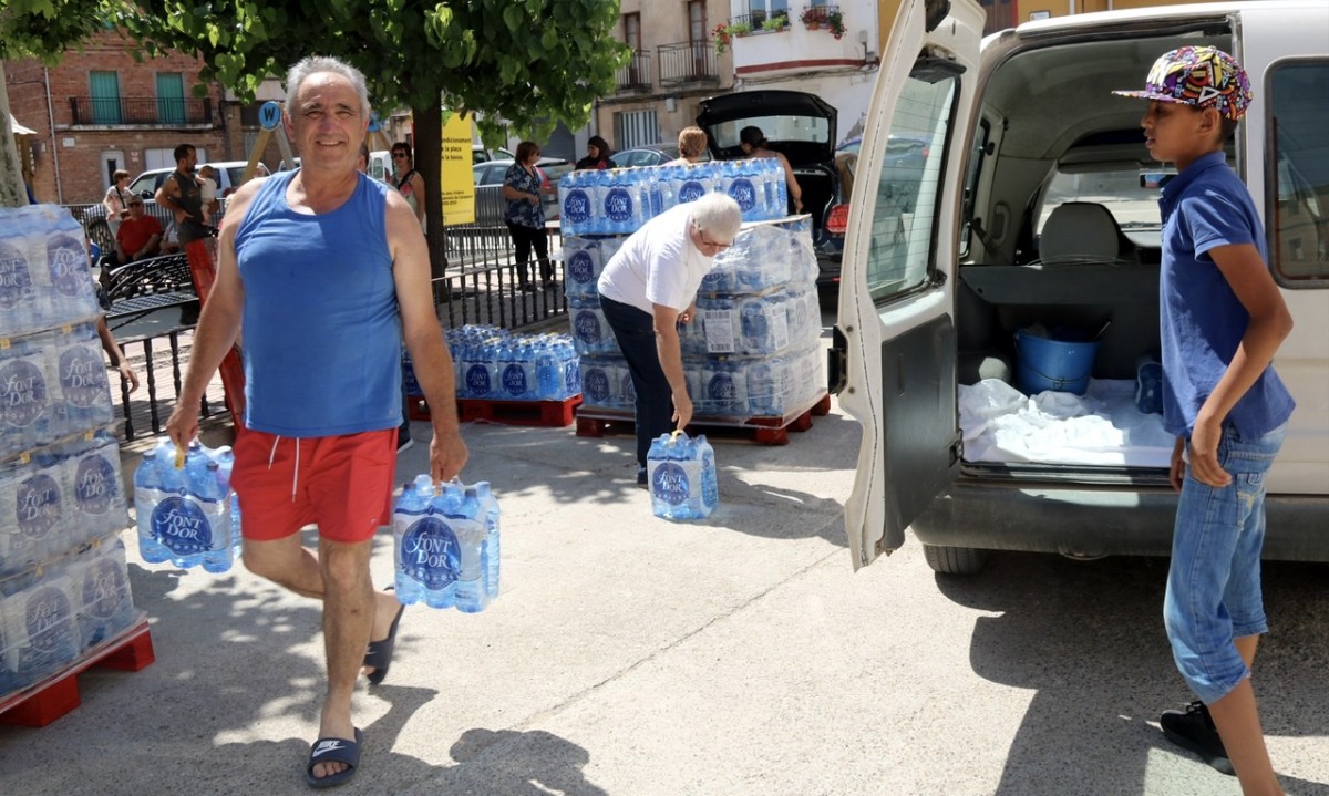 Veïns de Bovera recollint ampolles d’aigua.