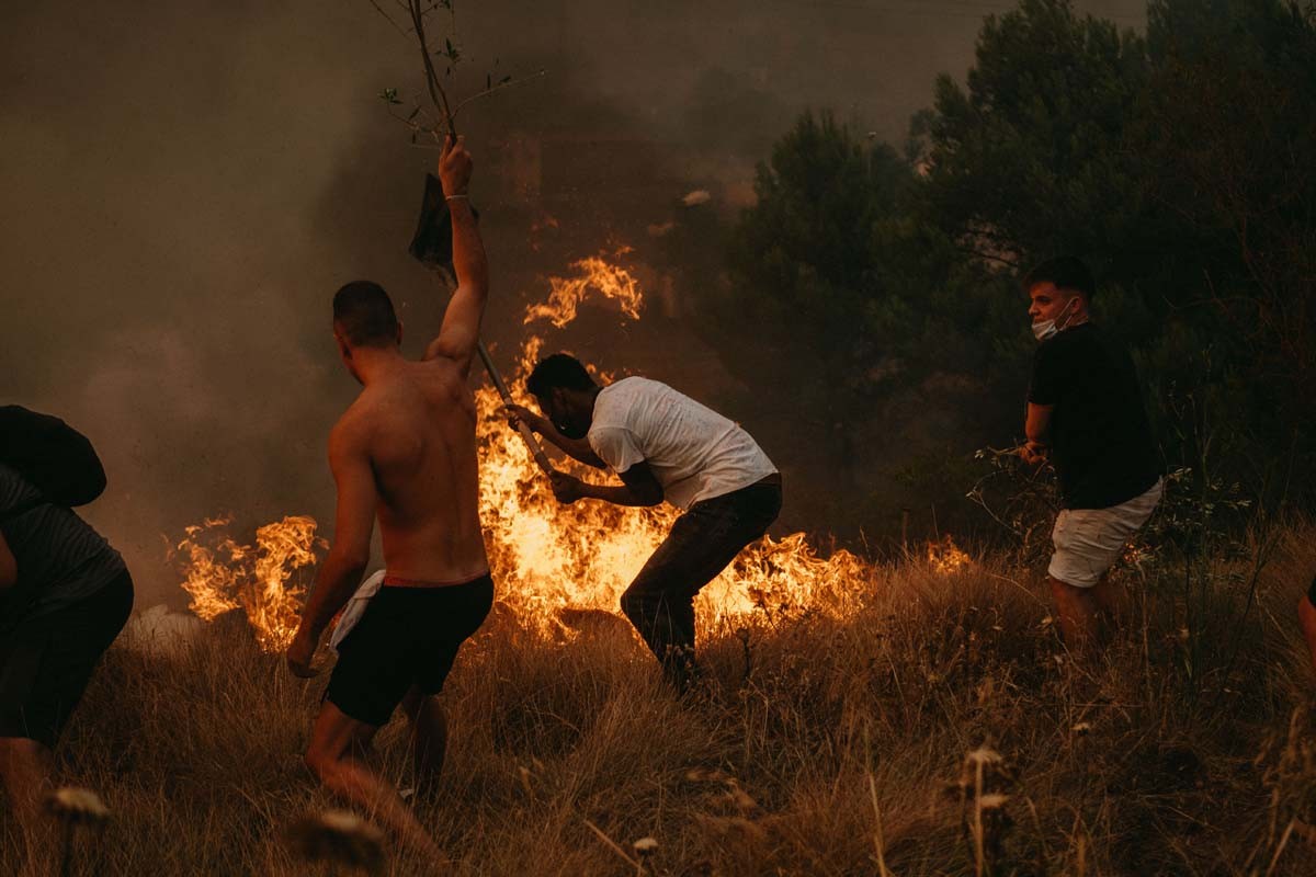 Veïns de Sant Fruitós intentant apagar les flames en un camp, en un incendi aquest estiu