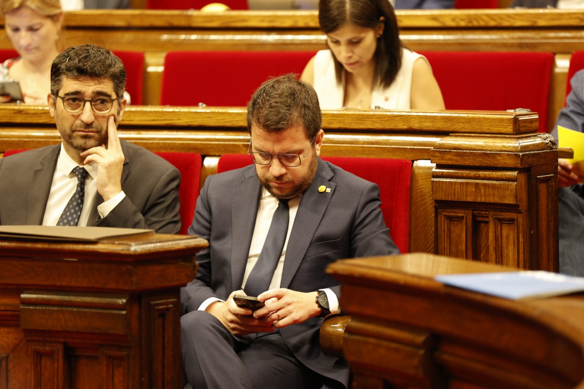 Pere Aragonès mira el mòbil al Parlament.