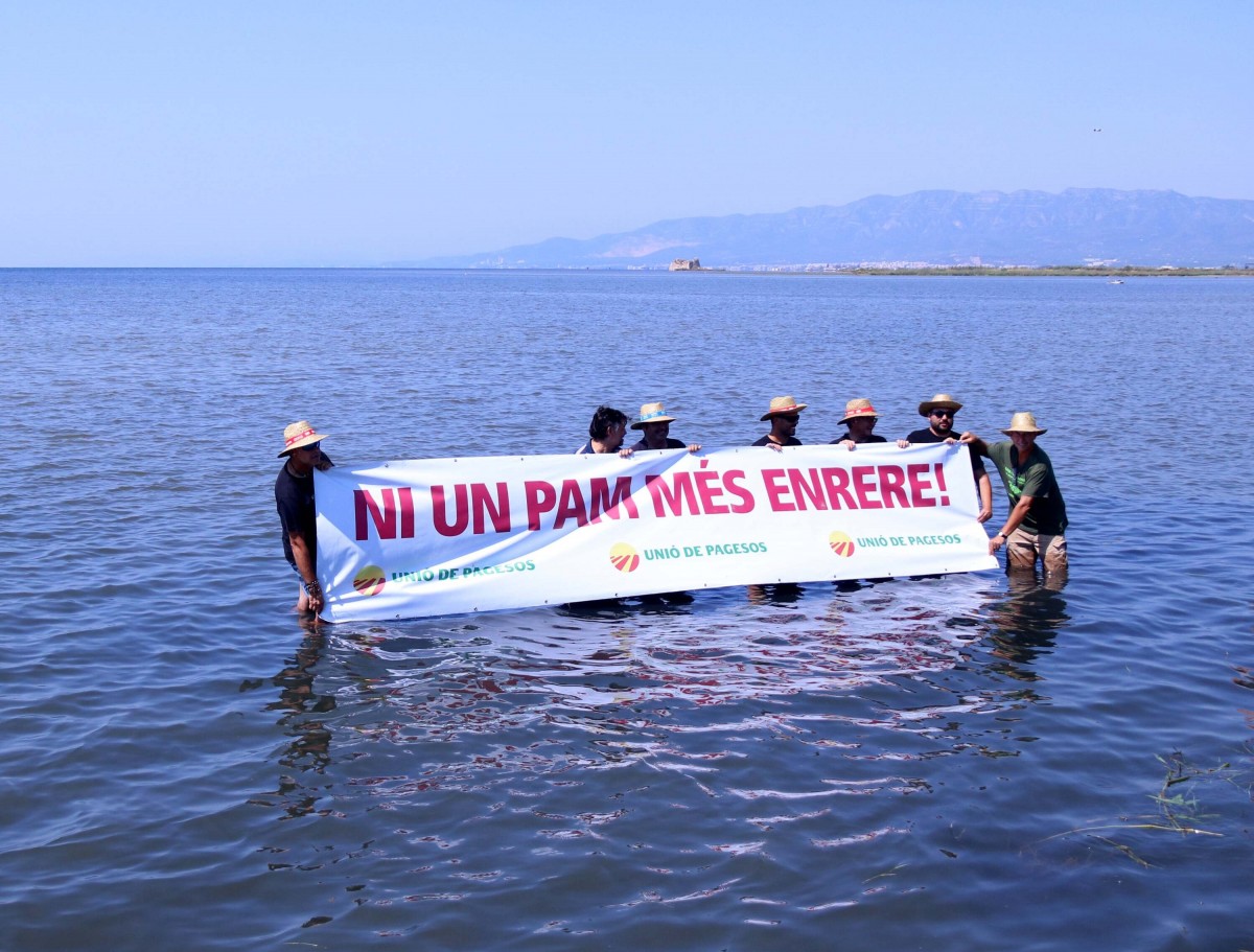 Membres d'Unió de pagesos subjectant una pancarta entrant a la badia dels Alfacs en l'acció per denunciar la regressió del delta
