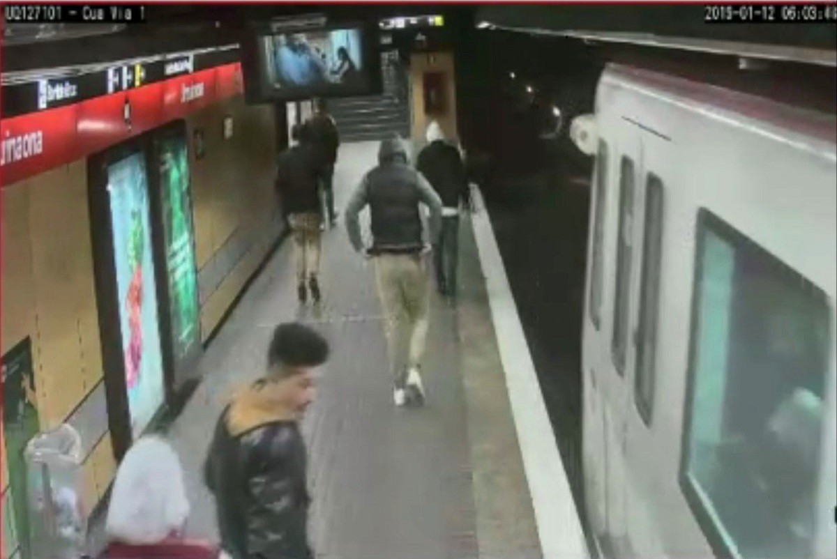 Imatge extreta del vídeo de seguretat on es veuen cinc joves seguint la víctima abans d'agredir-la al peu de l'andana del Metro