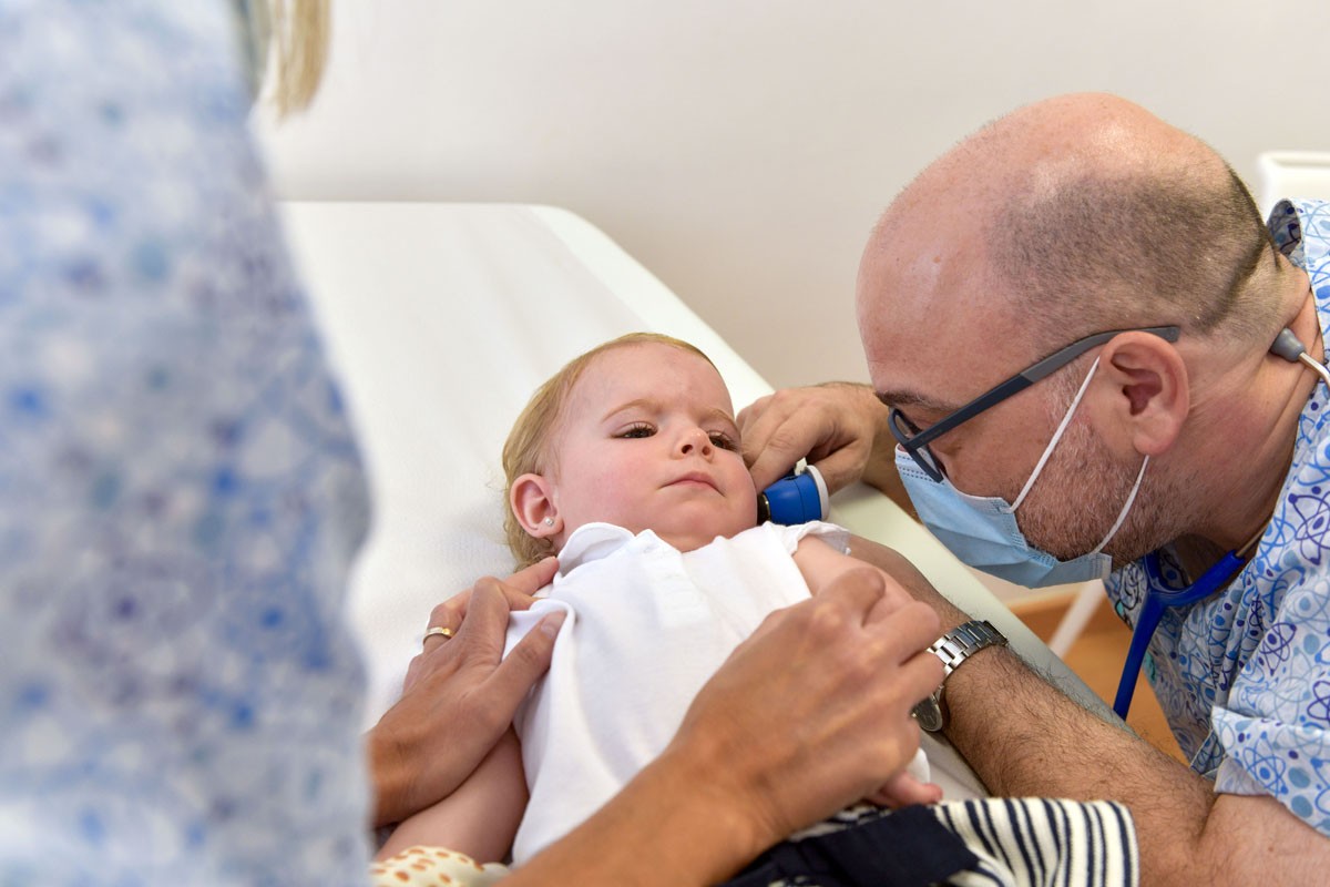 Dr. Marchena, pediatre de la Clínica Sant Josep, fent una exploració a les orelles d’una bebè