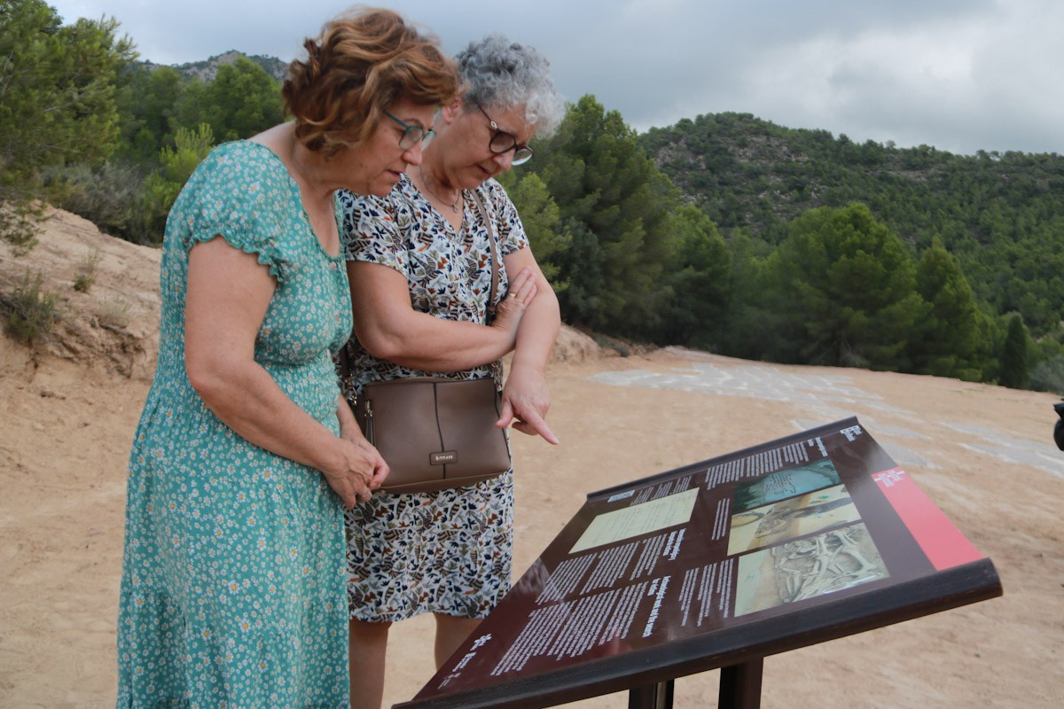 Dues dones llegeixen el plafó informatiu instal·lat al Mas de Santa Magdalena, a Móra d'Ebre