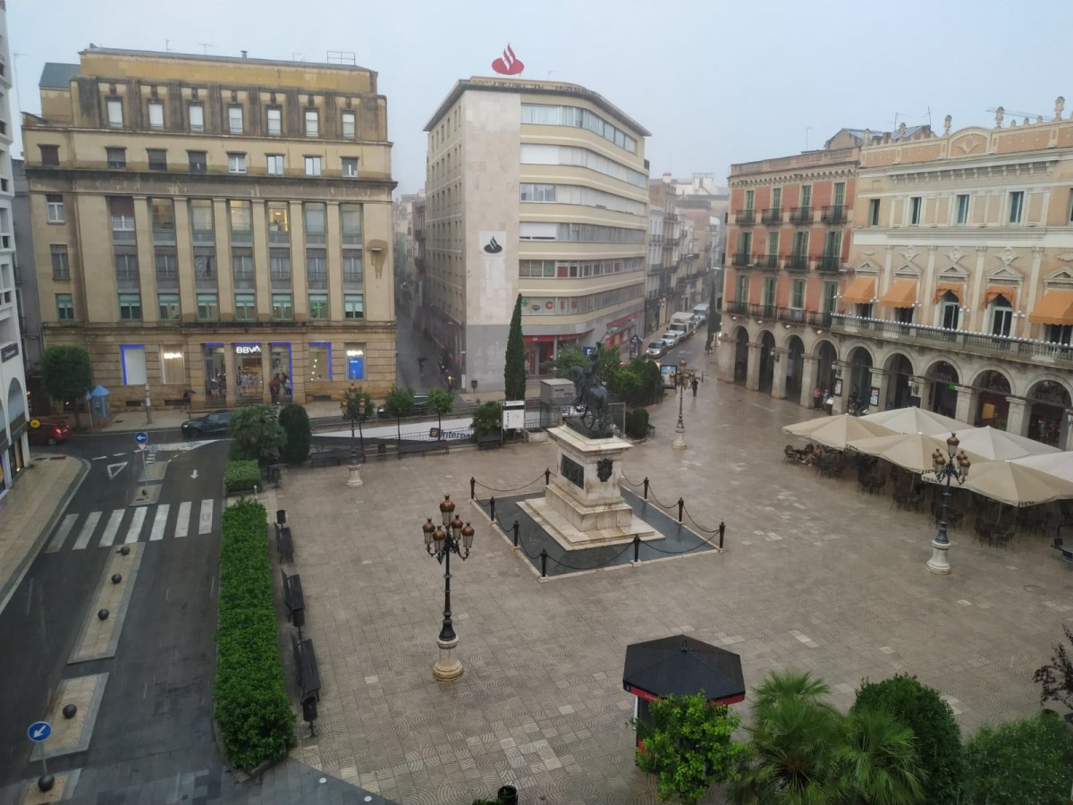La plaça de Prim, deserta de vianants, un cop ha començat a ploure