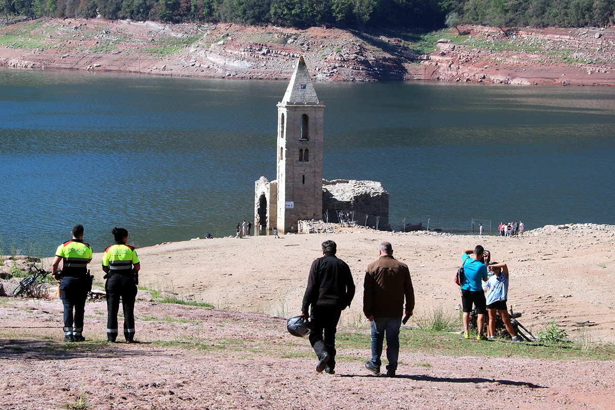 Dos agents dels mossos controlant els accessos el dissabte a l'església del pantà de Sau.