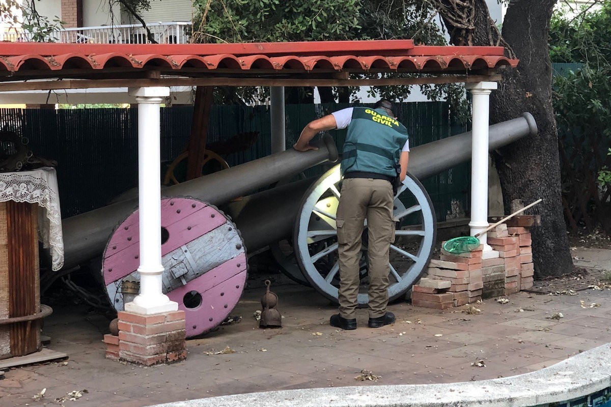 Un agent inspecciona un dels canons trobats al jardí de la casa